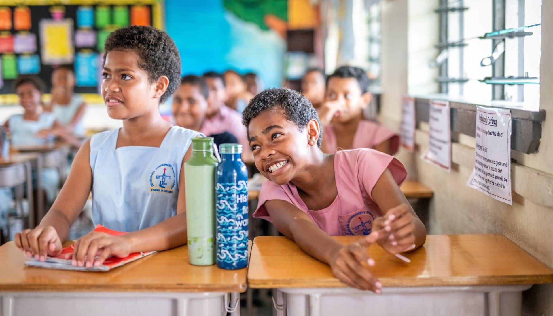 Two girls sitting at their desk at school